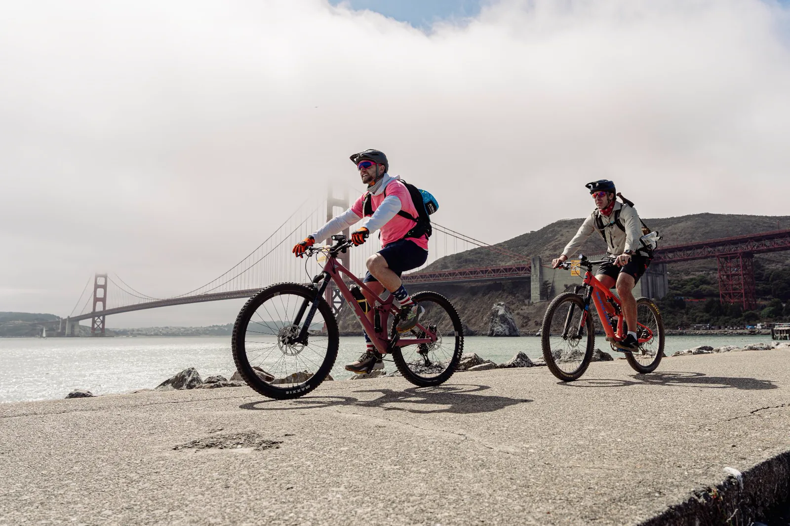 Two cyclists beside the Golden Gate Bridge