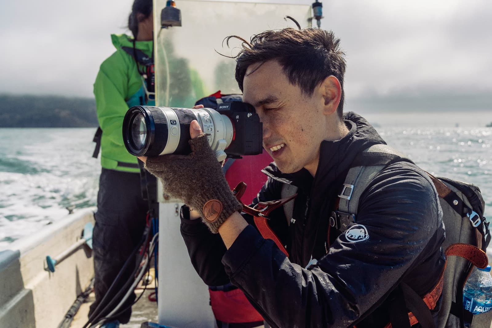 Photographer shooting with a telephoto lens from a boat on San Francisco Bay